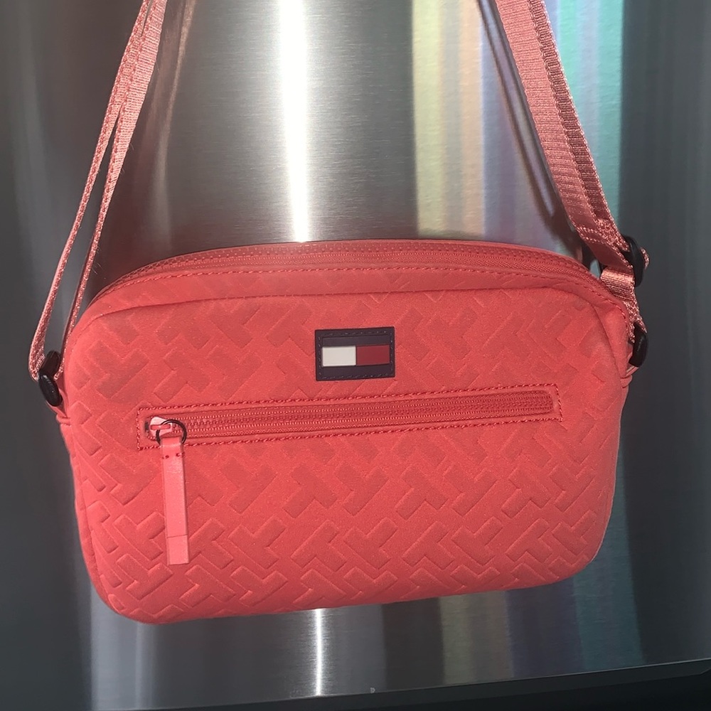 Coral Tommy Hilfiger messaged bag with adjustable straps.